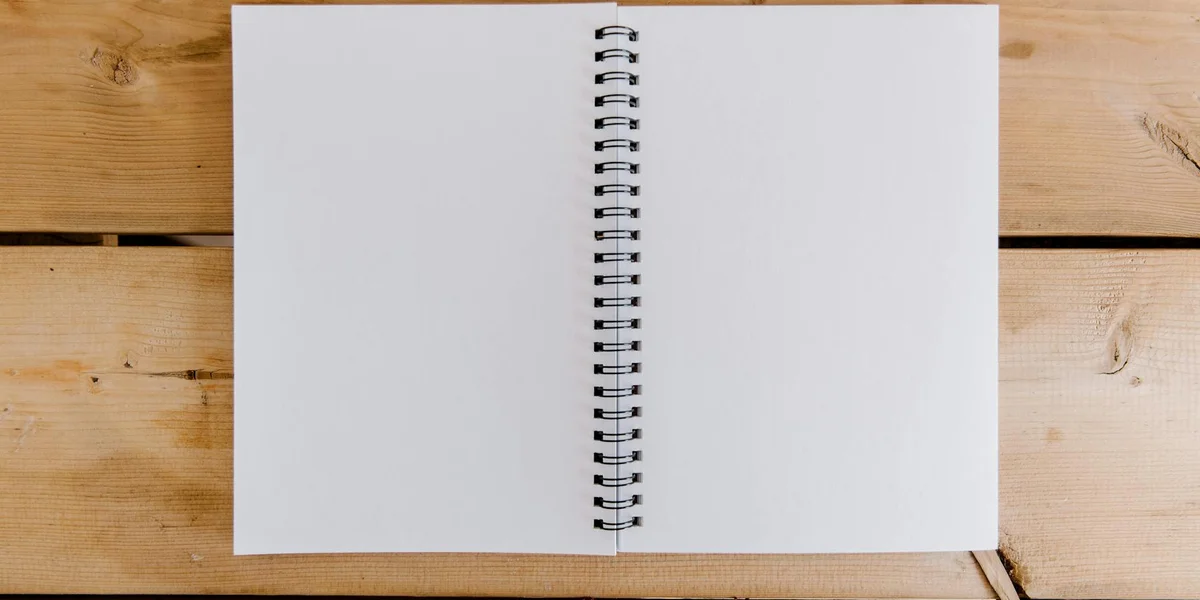 Open spiral notebook on a wooden surface, symbolizing a blank canvas for dream analysis.