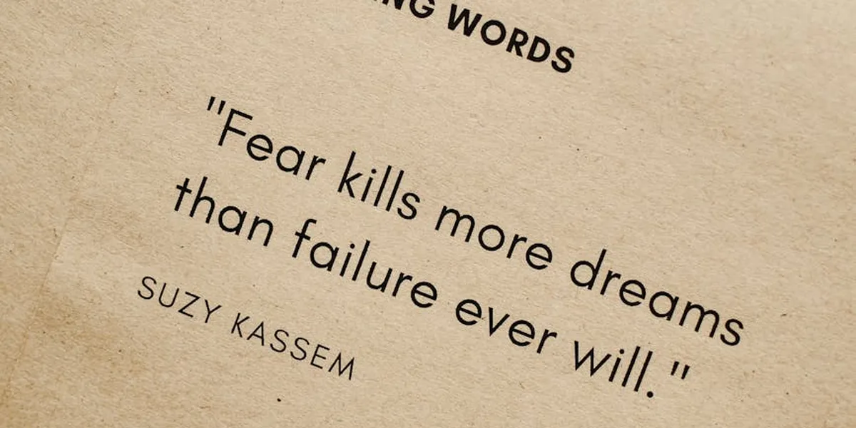 Beige textured background with a black quoted text: “Fear kills more dreams than failure ever will.” — Suzy Kassem