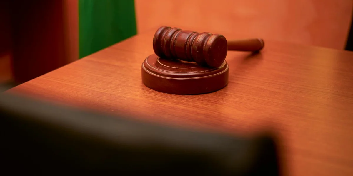 A judge's gavel resting on a wooden courtroom desk, symbolizing judgment and moral accountability.
