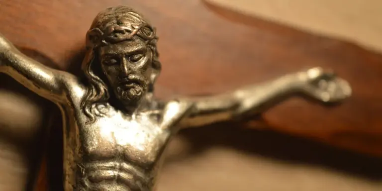 Close-up of a bronze crucifix statue depicting Jesus on the cross
