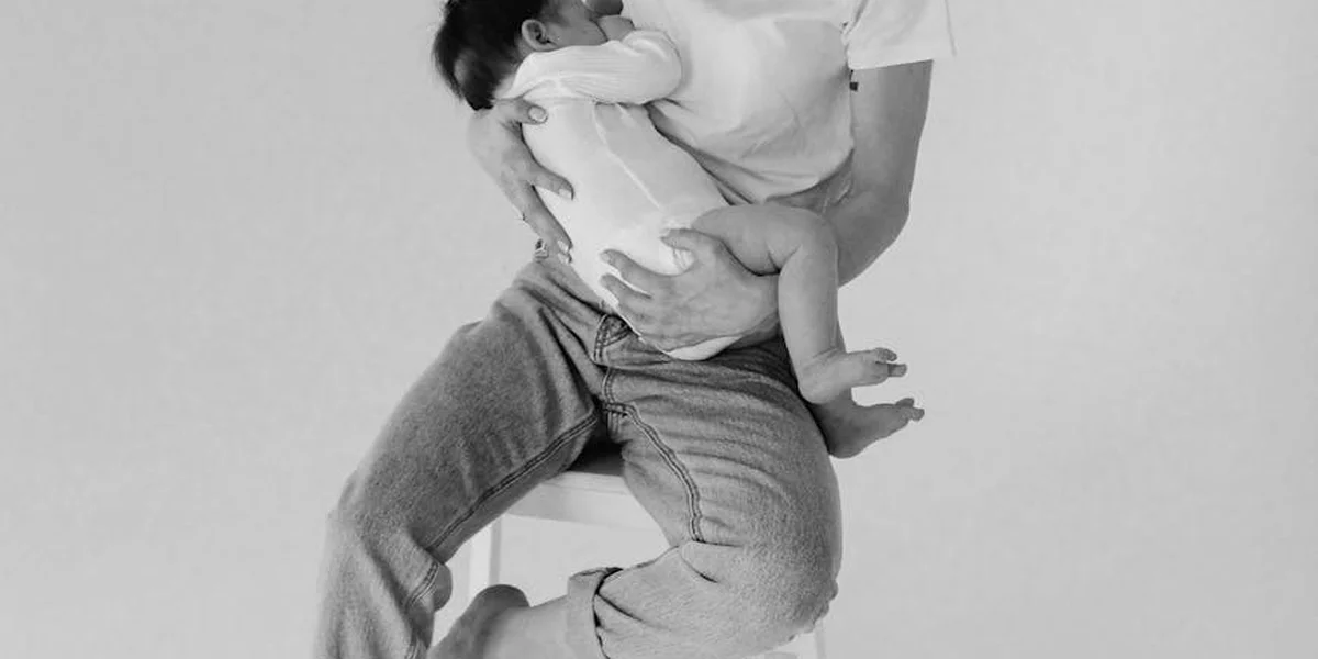 Black-and-white photograph of an adult embracing a small child on their lap, symbolizing comfort, memory, and the enduring bond with a mother.