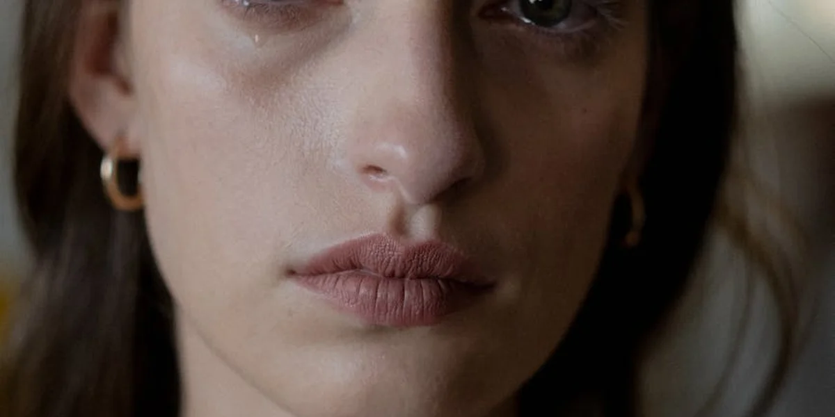 Close-up of a woman's face with a thoughtful, somber expression, suggesting introspection for dream interpretation.