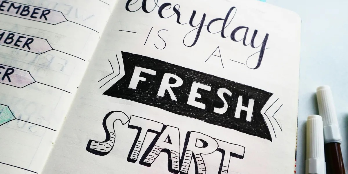 Open notebook with decorative typography reading 'Everyday is a Fresh Start', suggesting new interpretations of dreams.