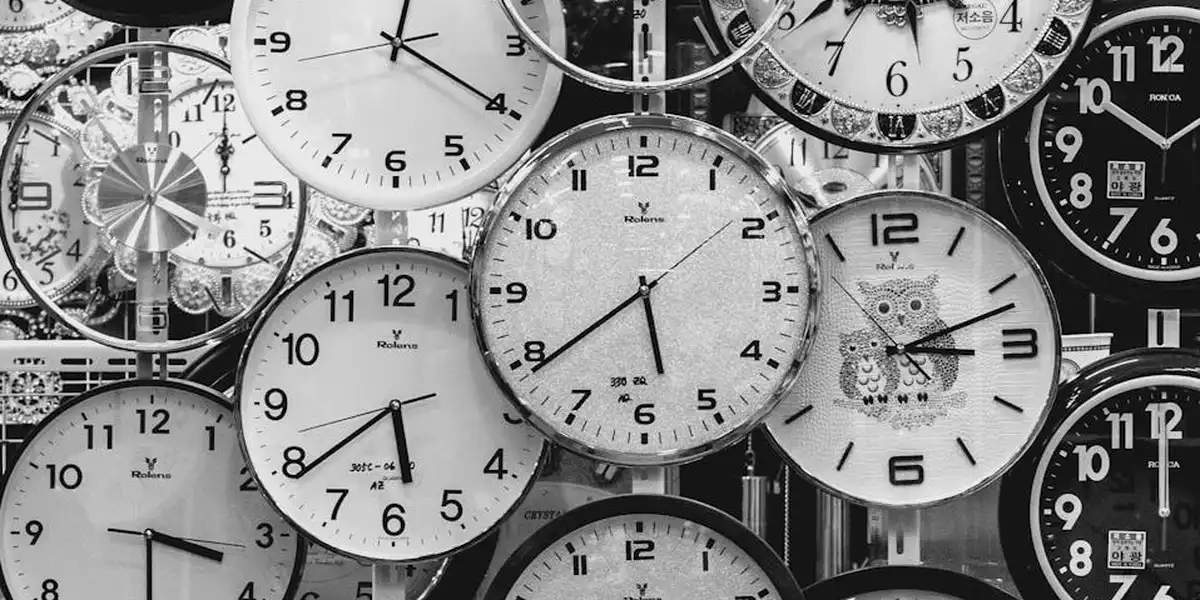 Grayscale collage of many clocks with numerous numbers, highlighting the prominence of numbers in dreams.