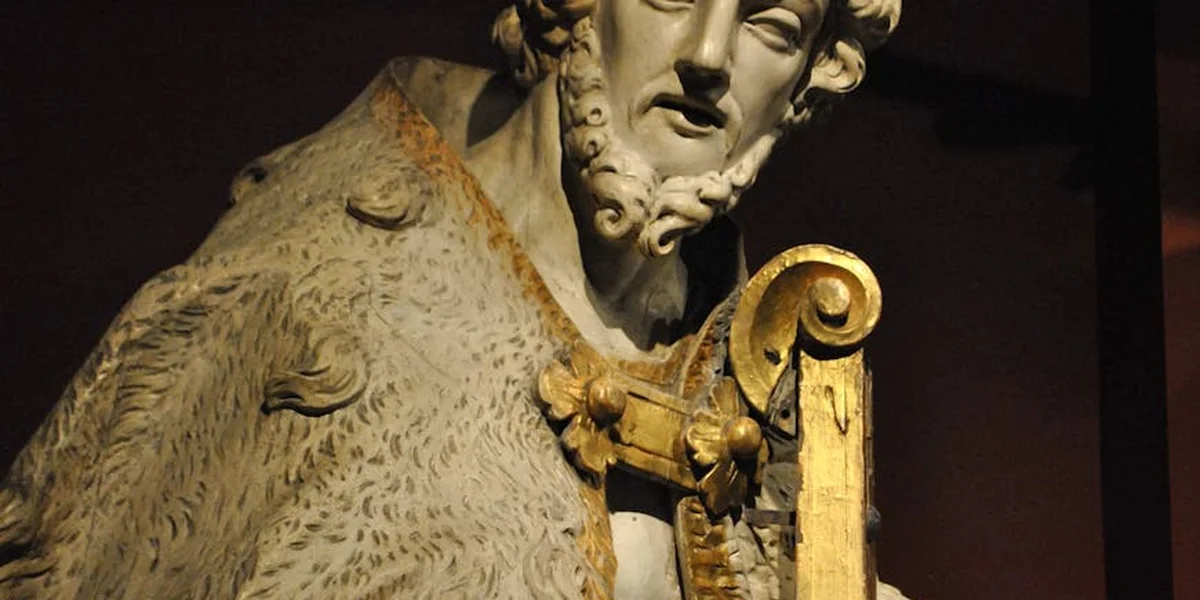 Classical marble bust of a bearded man wearing a cloak and holding a curved ceremonial staff, symbolizing leadership and authority.