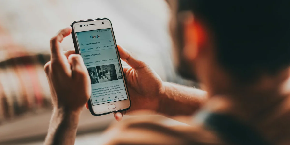 Close-up of a person holding a smartphone and looking at the screen, suggesting focus on messages and information
