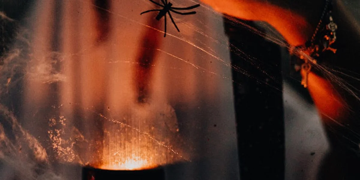 Close-up of a spider on a delicate web in a moody, orange-tinted light