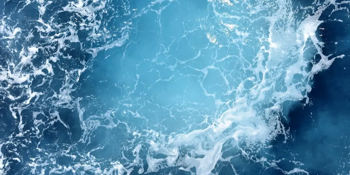 Aerial view of blue ocean with waves and white foam, representing dream imagery and the depths of the subconscious.