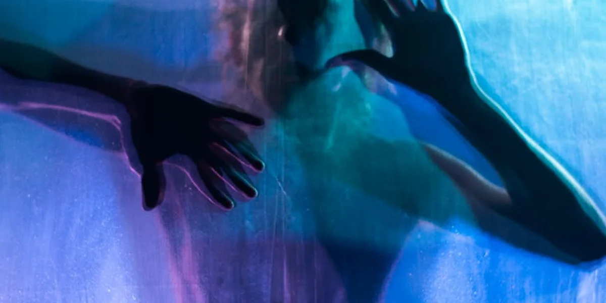 Hands reaching through blue water with blurred silhouettes, evoking emotional currents in dreams.