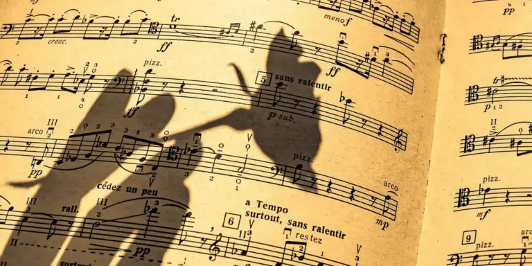 Shadowy hands over antique sheet music, suggesting listening to melodies and the symbolic link between instruments and dreams.