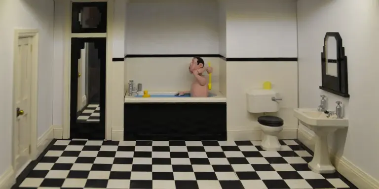 A bathroom with a black-and-white checkered floor. A person sits in a bathtub in the center, wearing a yellow top. A toilet and sink with a mirror are on the right, and a door is on the left; the walls are pale with a dark horizontal stripe.