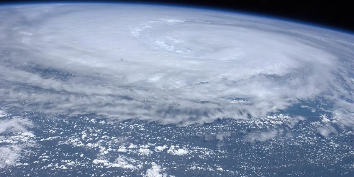 View of Earth from space with expansive cloud cover and storm systems over the oceans.