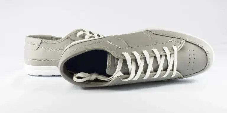 Gray sneakers with white laces on a white background