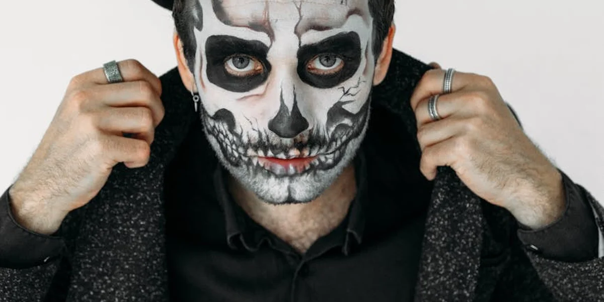 Person with skull face paint and dark clothing, evoking the Grim Reaper motif.