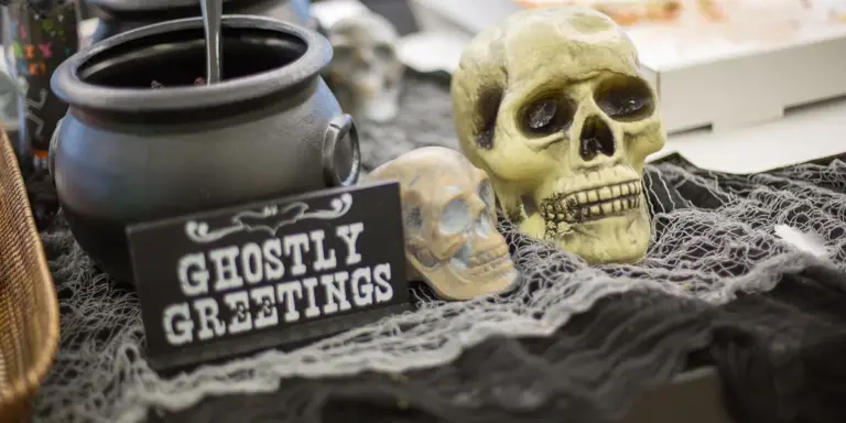 Halloween display featuring a skull, cobwebs, and a sign reading 'Ghostly Greetings'.