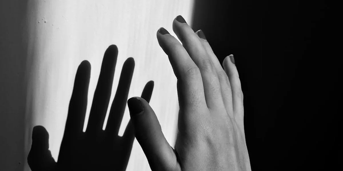 Black-and-white photograph of several hands reaching upward against a high-contrast background, suggesting dream symbols emerging from the unconscious.