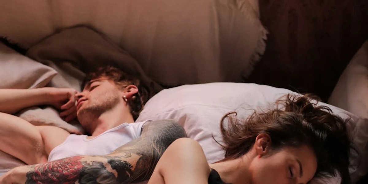 A man and a woman lie together in bed under soft lighting, suggesting intimate dream work and inner symbolism.