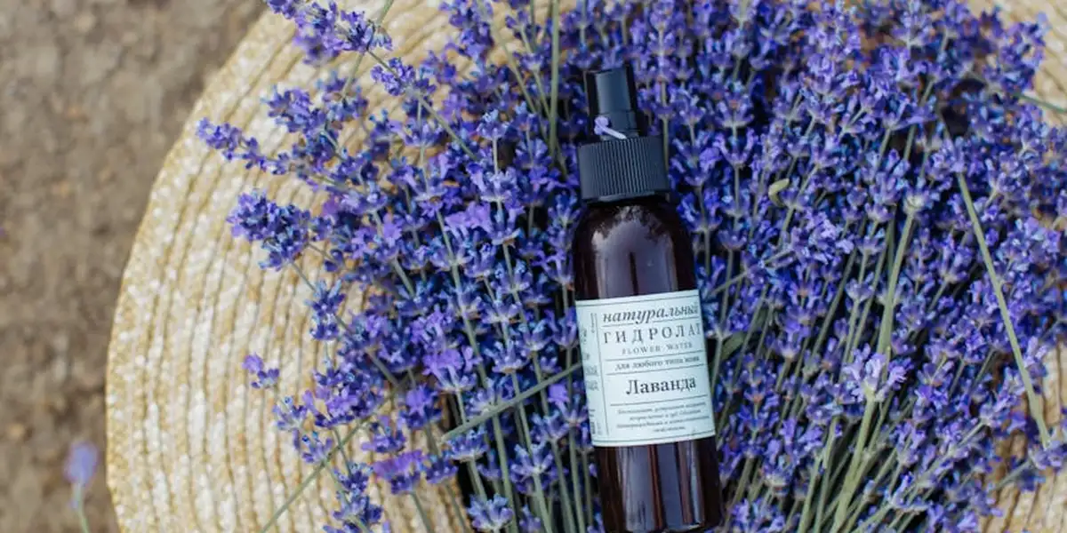 A bundle of purple lavender sprigs with a brown glass spray bottle on a wooden surface, illustrating lavender's role in dream symbolism.