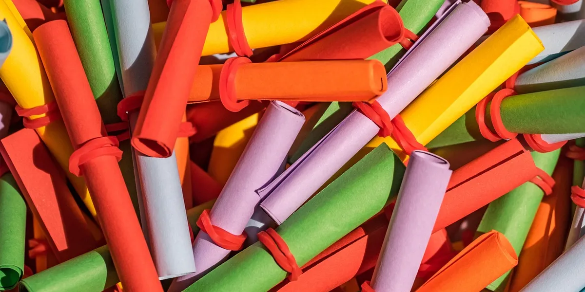 Close-up of colorful rolled confetti tubes tied with red bands, suggesting bursts of possibility.