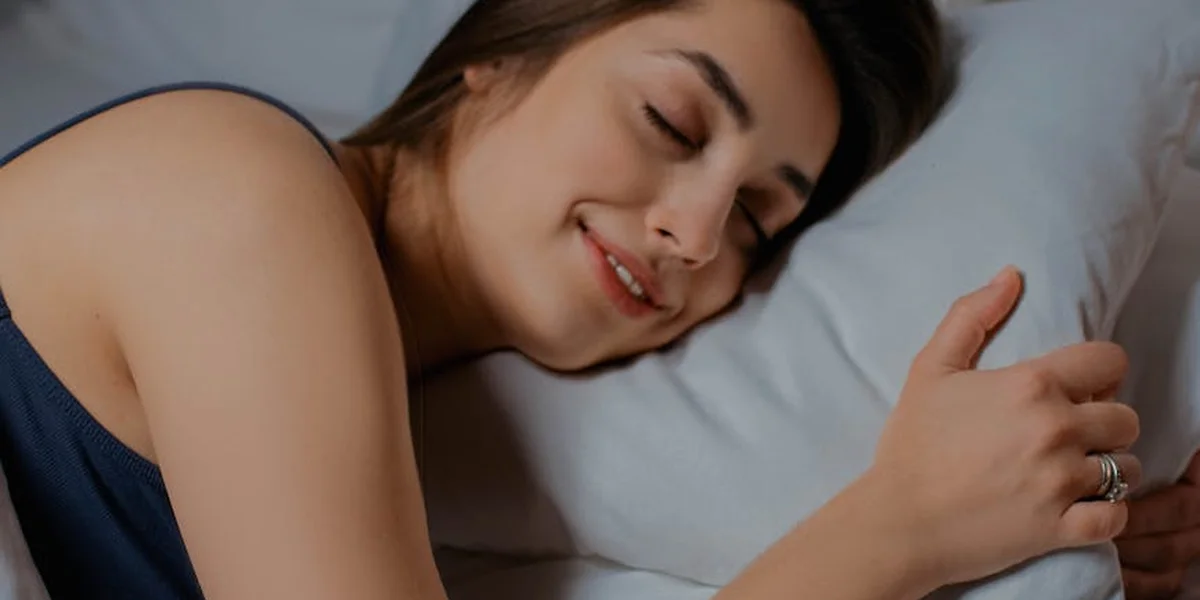 A person sleeping peacefully on a pillow, close-up of the face with a calm, content expression.