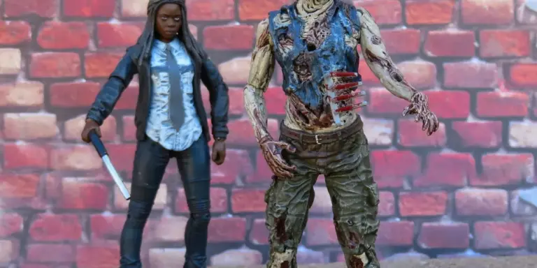Two action figures—a woman holding a knife and a zombie-like figure—stand against a red brick wall.