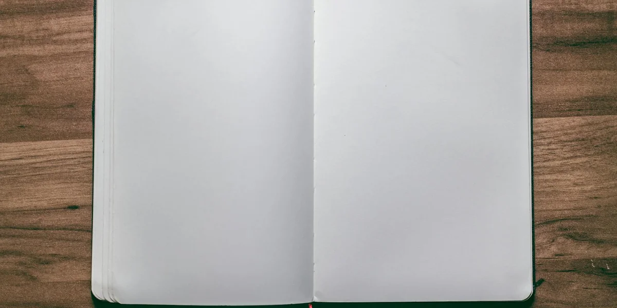 Open blank notebook on a wooden surface, inviting dream journaling and reflection.