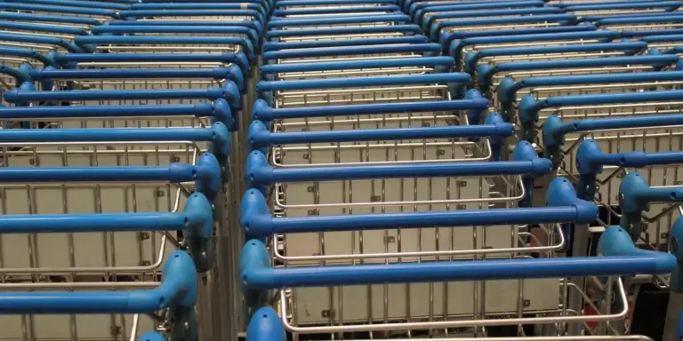 Blue shopping carts neatly lined up in rows inside a store.