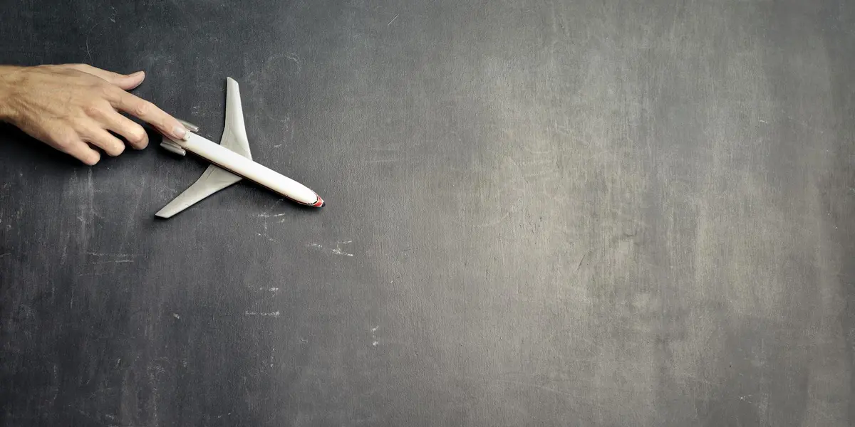 A hand holds a small hammer on a dark, chalkboard-like surface, symbolizing tools for exploring dream symbols.