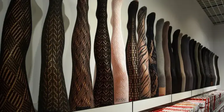 Rows of patterned and plain stockings hanging on a display rack in a store.