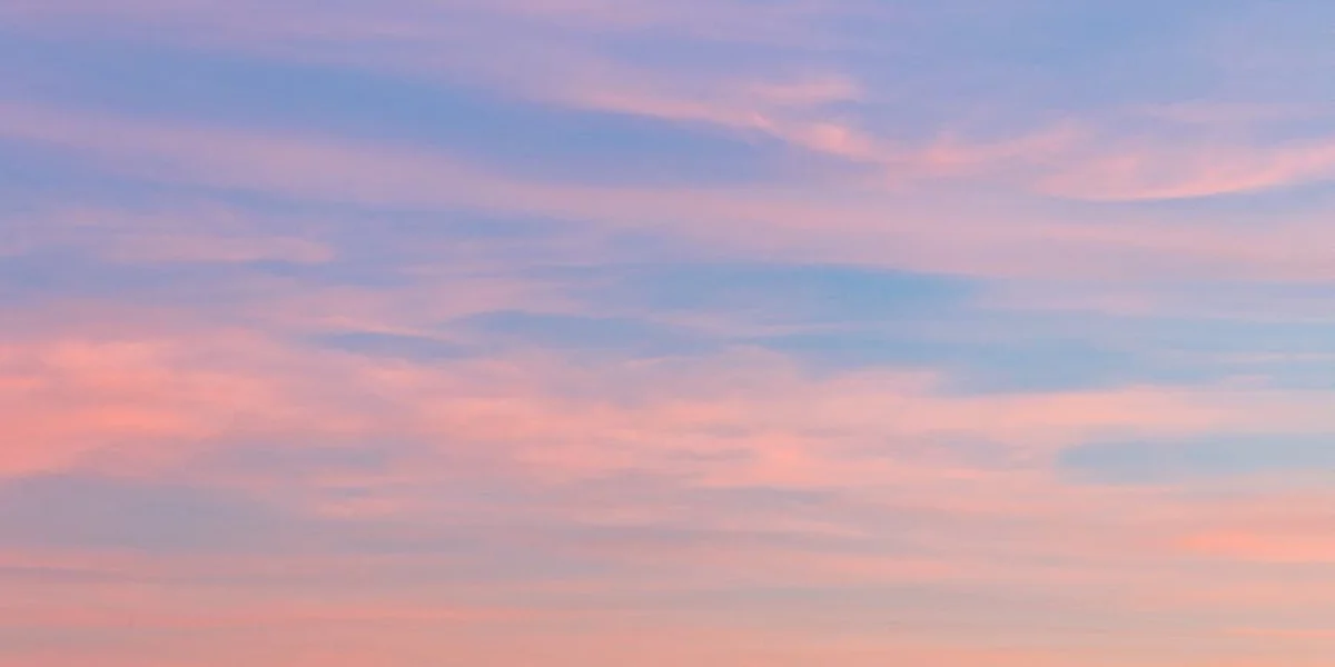 Soft sunset sky with pink, orange, and purple hues and wispy clouds.