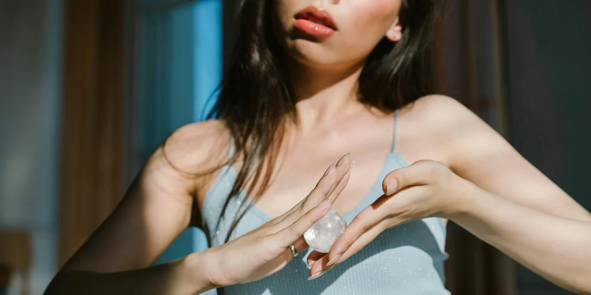 Close-up of a person holding a crystal between their hands, preparing to perform a ritual.