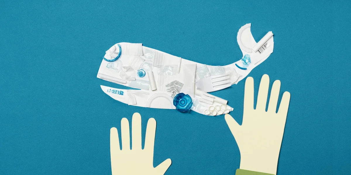 Blue background with a white collage whale made from newspaper and pale hands reaching upward