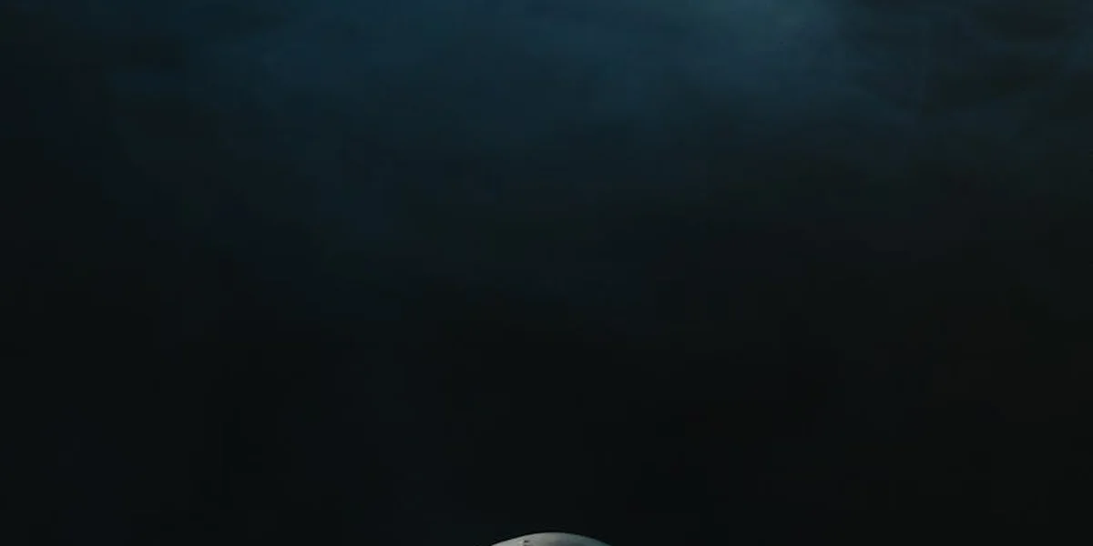 A dark, moody image with a subtle glow near the bottom, symbolizing insight emerging from work-related anxiety.